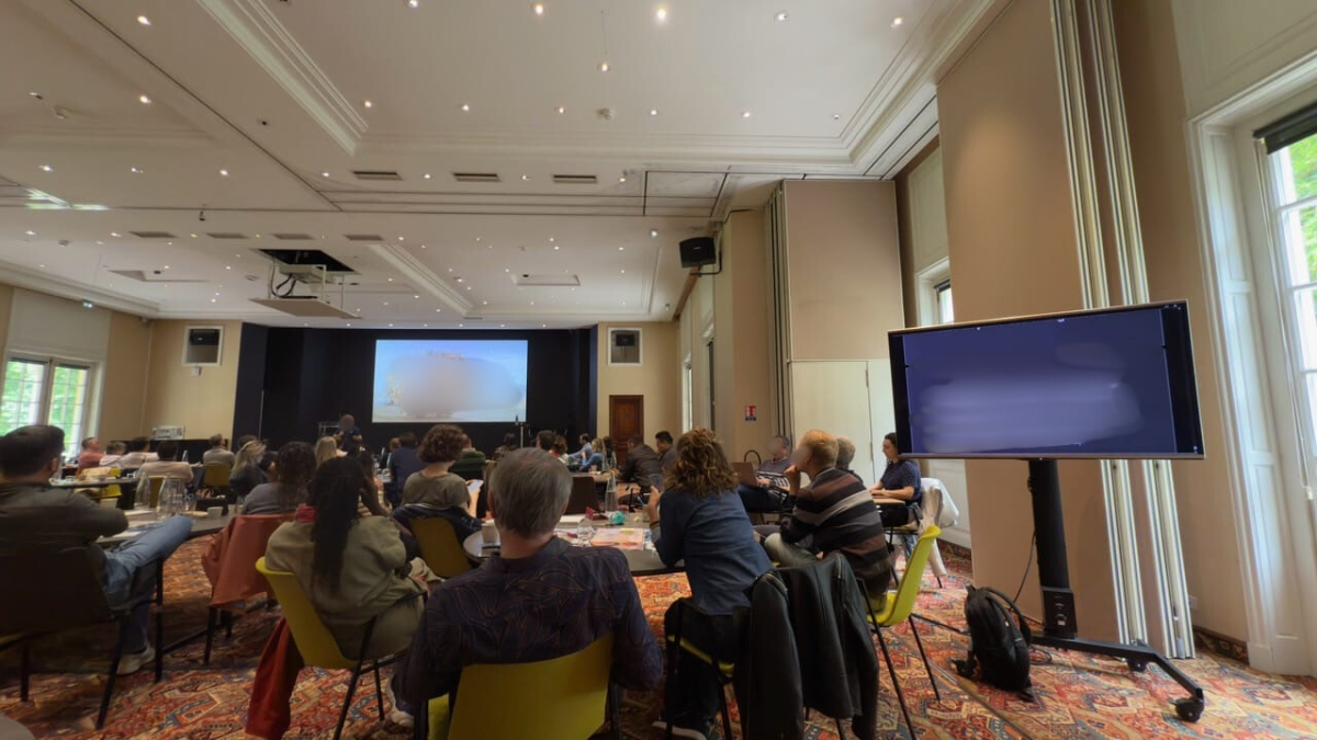 Dans une grande salle de réunion, Céline sous-titre en direct