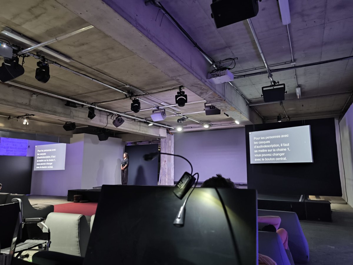 Deux écrans diffusent le sous-titrage à côté de la scène