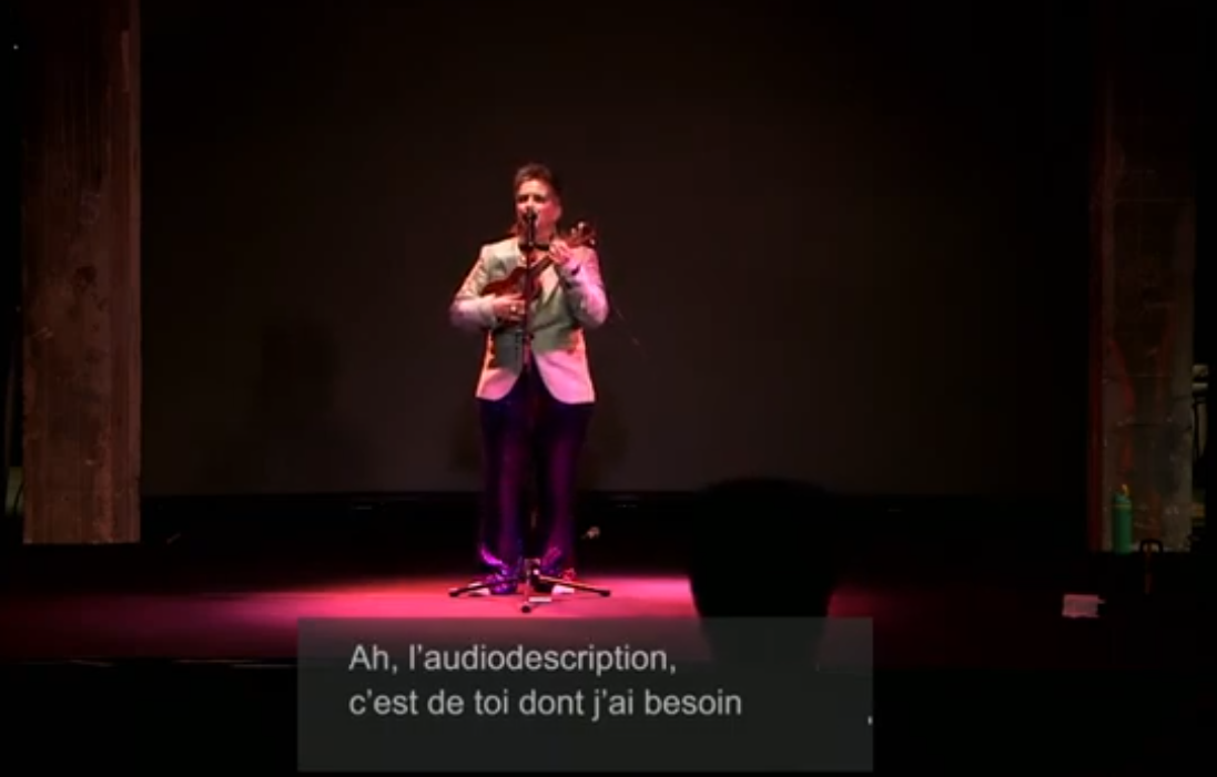 un drag king chante "l'audiodescription, c'est de toi dont j'ai besoin"