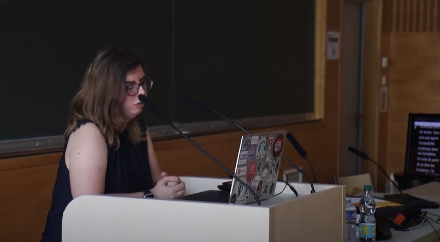 Une conférencière a un écran de sous-titrage installé à côté d'elle