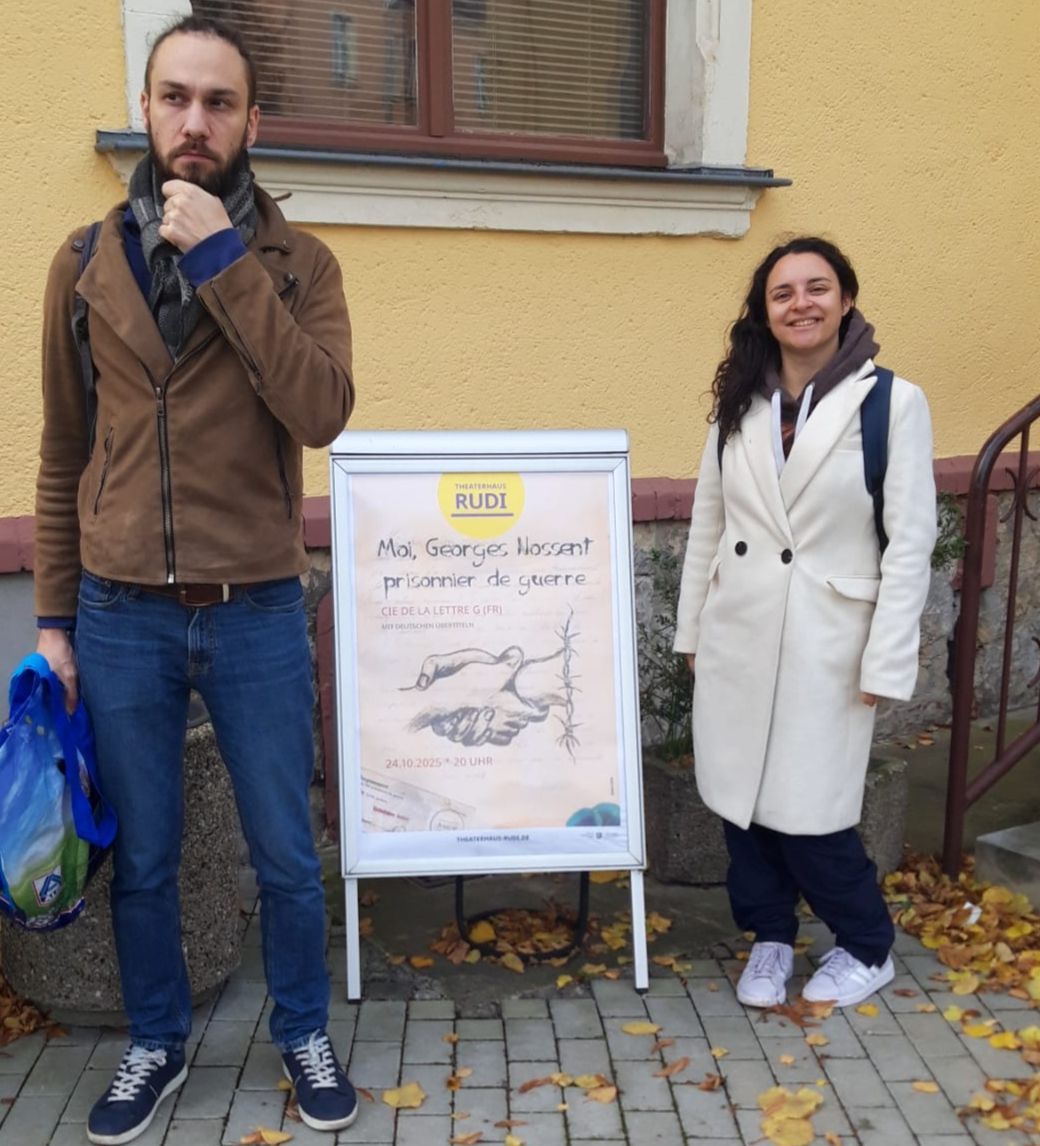 Céline sourit à côté de l'affiche de la pièce